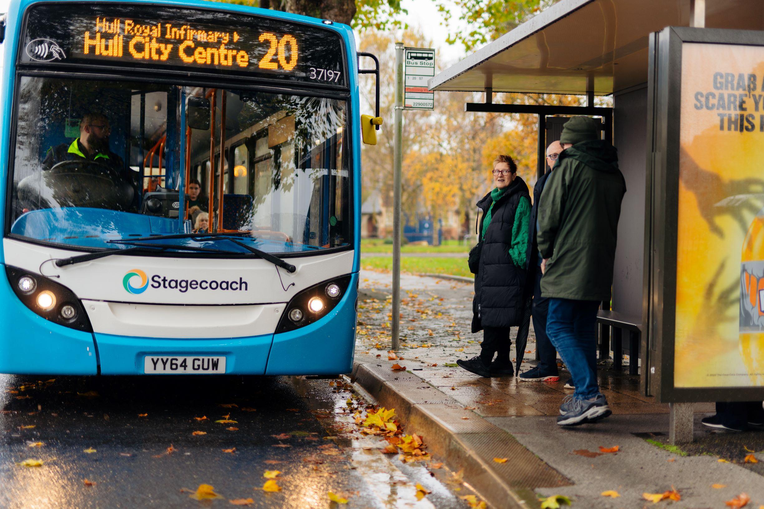 Photograph of people waiting to get on a blue and white Stagecoach bus.